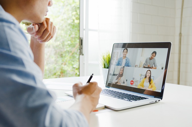 Man die met zijn laptop een videoconferentie volgt