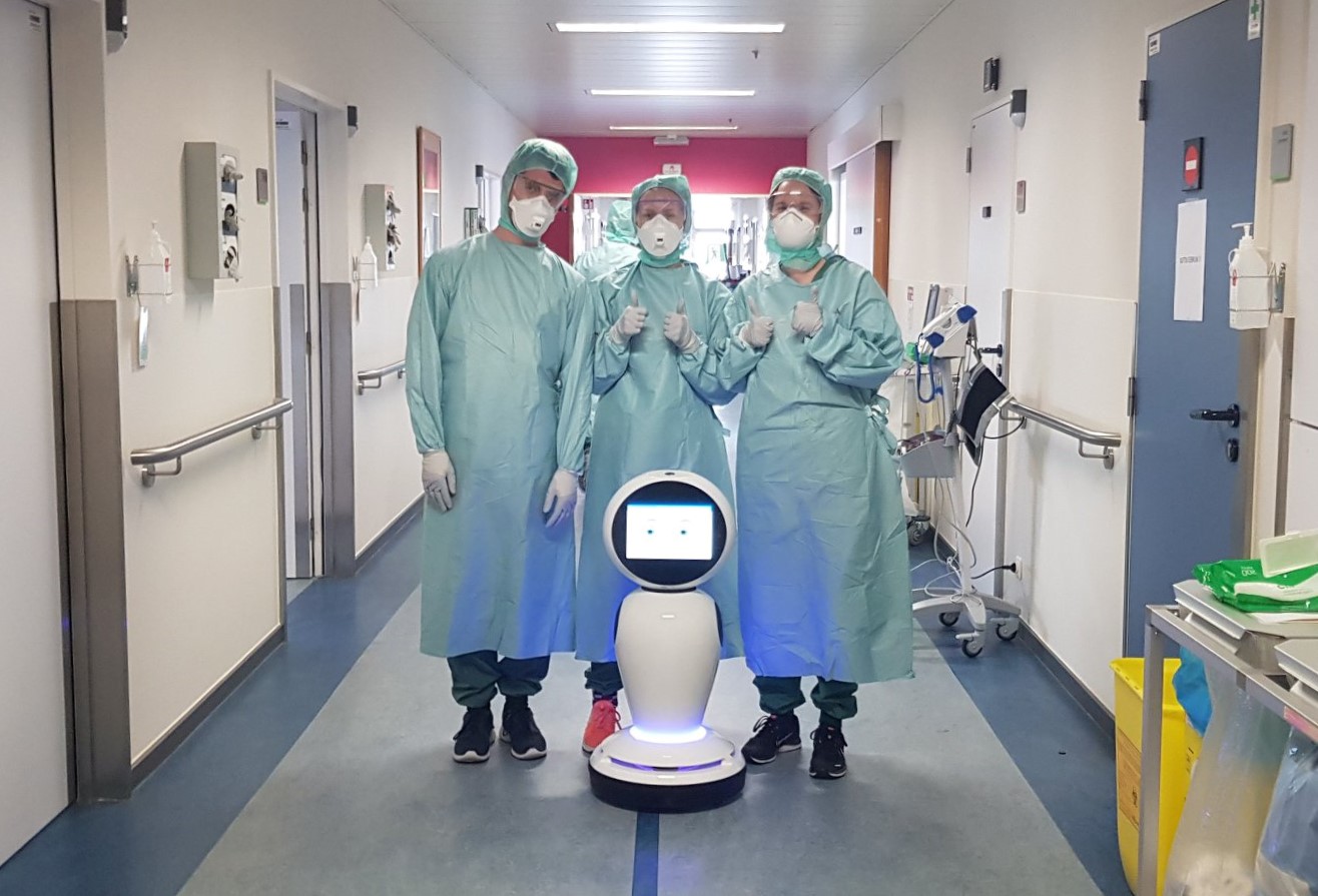 Het verplegend personeel van het ZNA ziekenhuis bij de robot die het ziekenhuis gedoneerd kreeg voor de covidafdeling