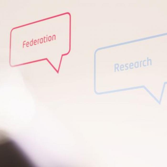 Twee tekstballonnen met de woorden "Federation" en "Research" op een witte achtergrond