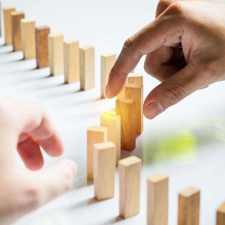 Two hands that put dominoes right