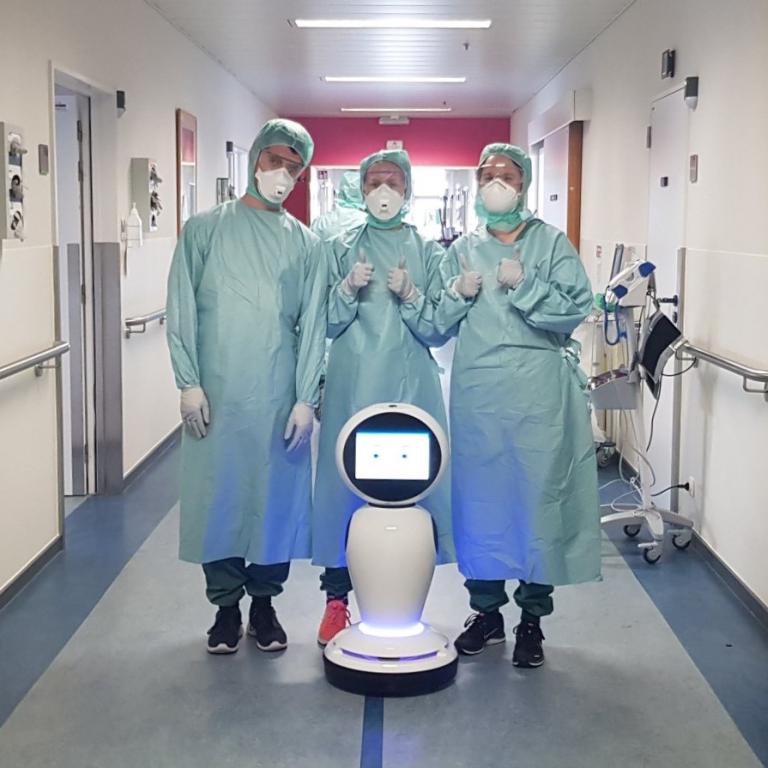Het verplegend personeel van het ZNA ziekenhuis bij de robot die het ziekenhuis gedoneerd kreeg voor de covidafdeling